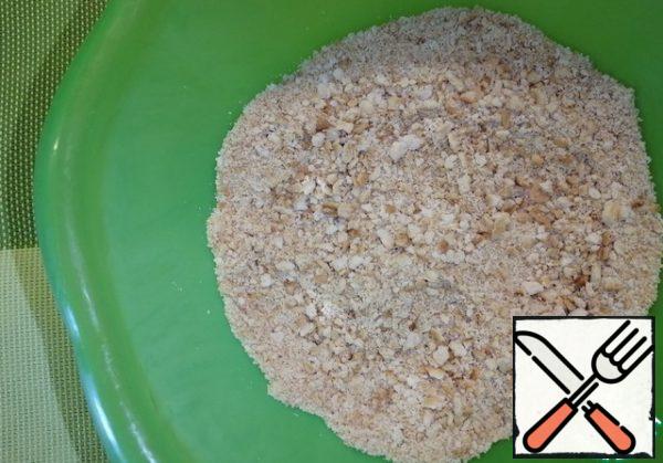 Crush the crackers in a deep bowl into crumbs. Melt the butter and pour it over the crumbs, mix well.