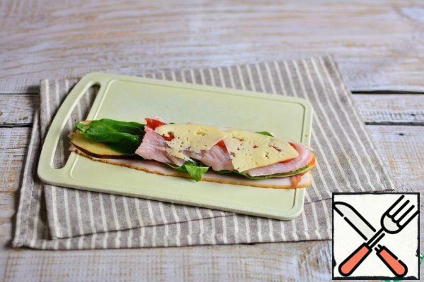 Then spinach leaves, turkey strips, a strip of ketchup, and half-length slices of cheese.