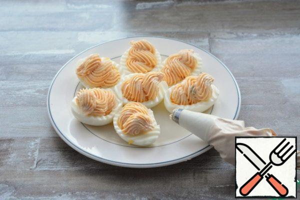 Fill the egg whites with the cheese and salmon mixture from the pastry bag.