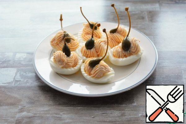 Garnish with capers or olives, or just a parsley leaf.

Eggs can be cooked in advance, cut and prepare the filling. In one container, remove the halves of the proteins, in the other container, remove the filling. The protein halves and the filling are stored in the refrigerator quietly for 2-3 days. And on the day of the holiday, stuff it.
