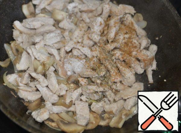 Return the fried turkey to the pan. We put salt, a mixture of peppers, Provencal herbs. Mix it up.