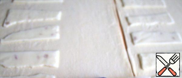 Cut the cheese into strips and place on the dough.