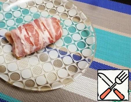 Roll the chicken pieces into a roll and wrap them in strips of raw bacon. It took me two strips for each roll.