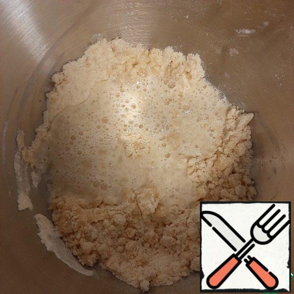 Pour in the vegetable oil, mix until crumbs form.
Add the vinegar to the water and pour it into the dough.