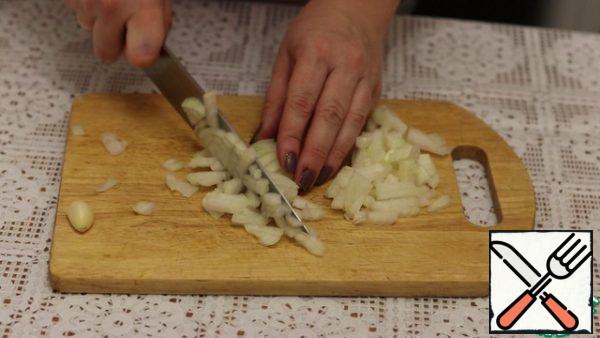 Peel the onion and cut it into cubes.