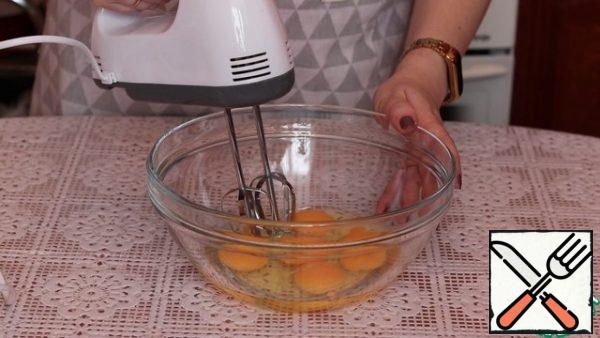 In a deep bowl, break the eggs and beat them into a fluffy foam. Eggs should be at room temperature, then they will be better beaten.