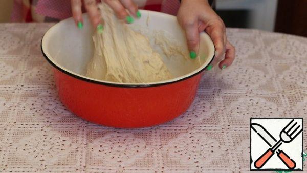 In the sifted flour, add salt, sugar, yeast, and butter. Mix thoroughly, pour water and knead the dough. It will be a little liquid and will stick to your hands a little.