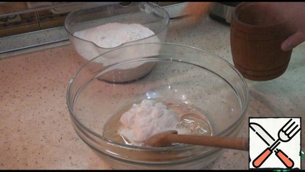 Then add sunflower oil, sour cream, salt, stir. Gradually add the flour and knead the soft, slightly sticky dough. Flour may need a little more or a little less.