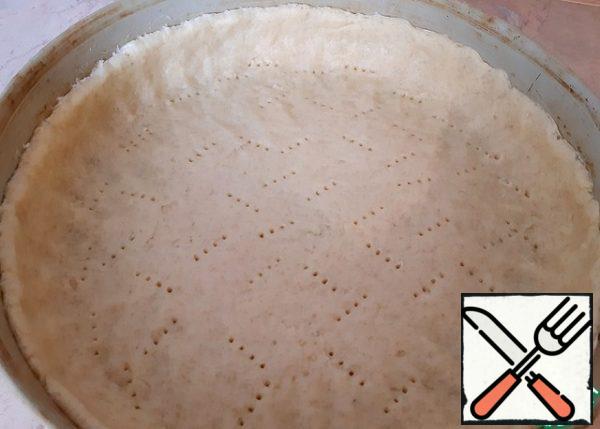 Now the dough should be placed in a greased form, form the sides, prick with a fork, so that it rises evenly.
In this case, I have a large shape with a diameter of 30 cm.
But you can bake portioned cakes-baskets. Then roll out the dough, cut out the circles and put them in the molds for cupcakes or muffins.