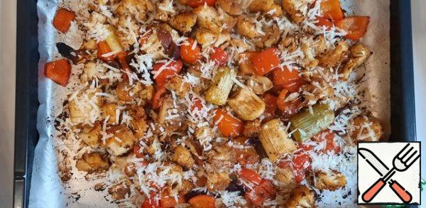 After the allotted time, try the vegetables, they should be soft, otherwise leave in the oven for a while longer.
Remove the vegetables from the oven and immediately sprinkle with Parmesan. Set aside a couple of pieces of cabbage for serving.
Parmesan can be replaced with any other cheese or even excluded.