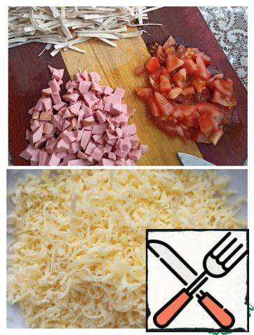 Cut into cubes a medium-sized tomato (about 100g) and boiled sausage. Grate the cheese on a medium grater