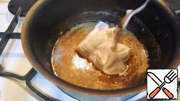 While the cheesecakes are being prepared, we will prepare the sour cream and honey sauce. To do this, 60 g of softened butter is transferred to a preheated saucepan. When the butter is almost melted, add 20 g of honey and a pinch of cinnamon. Mix everything together. Then turn off the heat and add 100 g of sour cream.