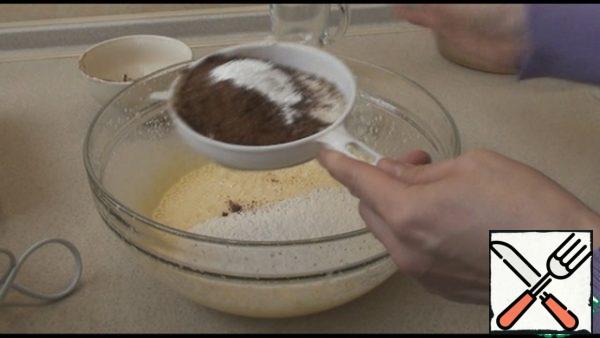 Pour in the sunflower oil, stir, then milk, stir again with a mixer. Sift flour, cocoa and baking powder. Mix the dough well with a spatula, so that there are no lumps.