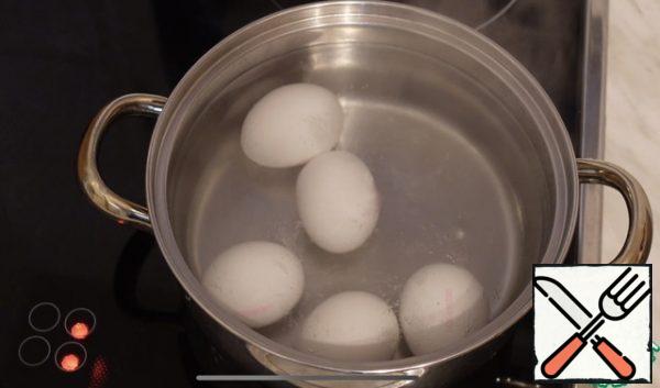 In boiling water, put the eggs, boil for 5 minutes, so the yolk will remain liquid.