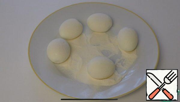 Boiled eggs are rolled in flour.