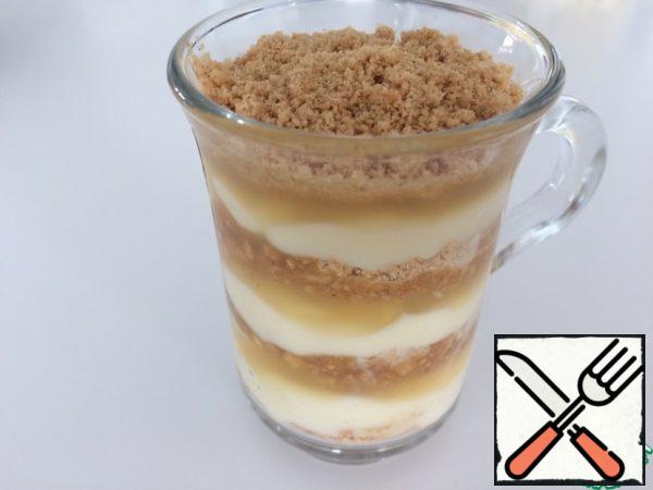 We collect our dessert, adding a teaspoon: a mixture of cookies with nuts, custard, bananas, caramel sauce, and so on until the glass is filled.