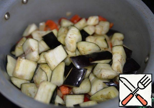 We wash off the eggplant, squeeze it out, and put it with the vegetables. Stir, fry for 5 minutes.