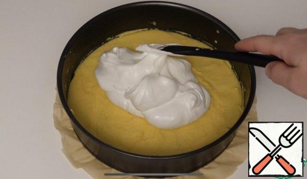 In a baking dish of 26 cm, spread the baking paper on the bottom, then spread the sponge dough, spread it well on the bottom, spread the meringue well on top