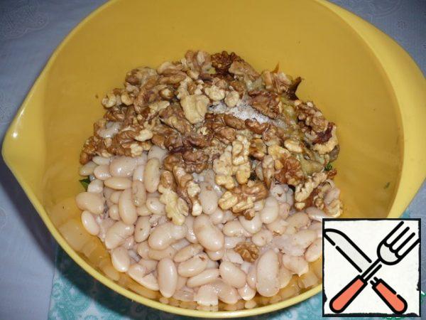 In the same place, add the boiled beans, the flesh of the baked eggplant, toasted walnuts, and olive oil to the bowl. Add salt to taste.