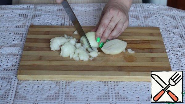 First, prepare the sauce. To do this, cut the onion into cubes.