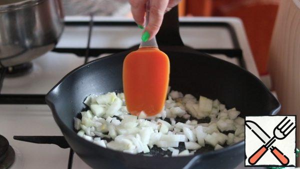 In a preheated frying pan with the addition of oil, fry the onion until transparent.