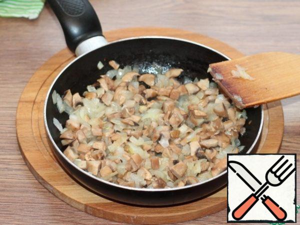 Prepare the filling. Fry the diced onion in preheated vegetable oil until transparent. Add finely chopped mushrooms, spices and salt, fry for 5 minutes, not forgetting to mix periodically.