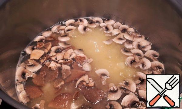 As the corn groats boiled, we send mushrooms and porcini mushrooms to the soup.