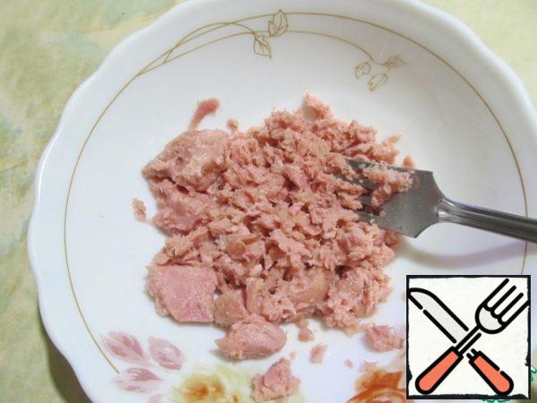 Put the tuna slices in a bowl and mash with a fork.