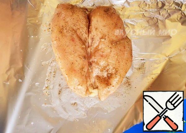 Put the chicken fillet on the foil, salt and pepper to taste, add the seasoning for the chicken, you can optionally paprika. Then add the vegetable oil and distribute it evenly. Wrap the foil, put it on a baking sheet and bake at a temperature of 200° for about 30-35 minutes.