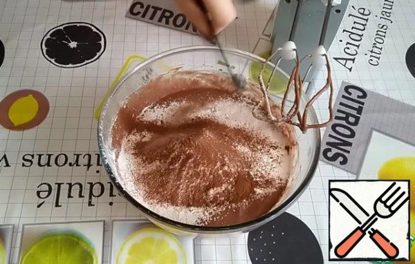 Add the orange zest, ground hazelnuts.
Sift the flour together with baking powder and cocoa powder.
In addition, add ground allspice, cinnamon, nutmeg.