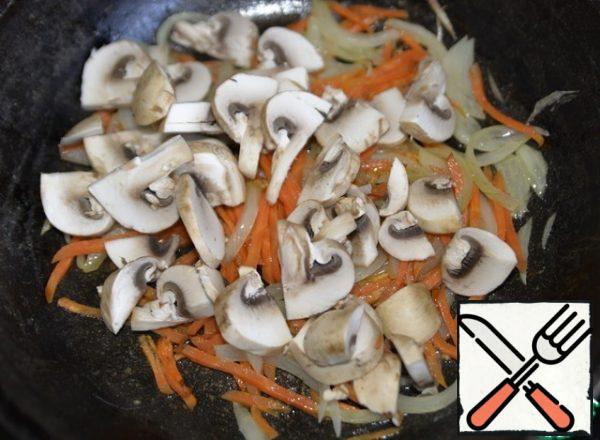 In a frying pan, fry the onion and carrot in oil until lightly browned. Put the mushrooms in the pan. Stir, fry.