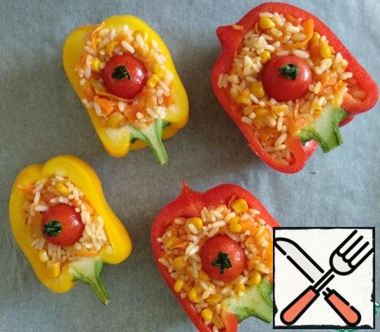Arrange the filling in the pepper halves. Spread the cherry tomatoes on top. Transfer the peppers to a covered baking sheet. Cook in the oven for 20 minutes. at a temperature of 190 degrees. Then turn off the oven and leave the peppers there for 10 minutes.