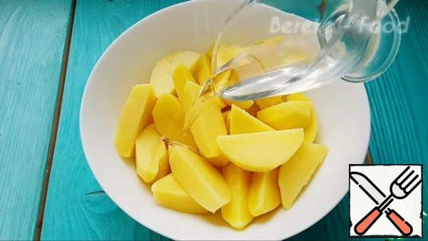 Pour vegetable oil into the potatoes and mix everything together.