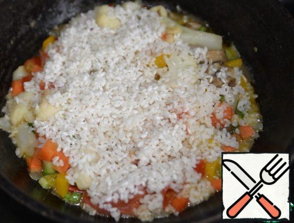 Take the rice, wash it. Evenly cover the top of the vegetables with rice.