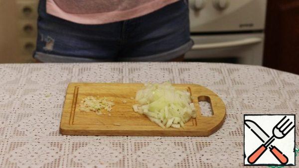 Onions are cleaned, washed and finely cut into cubes. Peel the garlic and finely chop it.