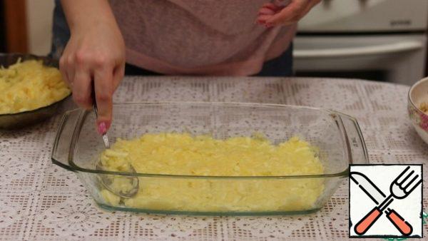 We take a refractory form, lubricate with vegetable oil. Spread half of the zucchini, after squeezing it out.