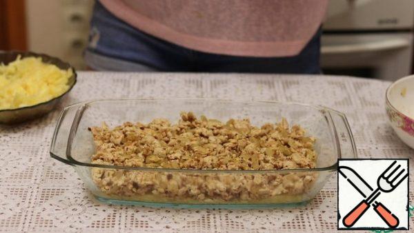 The second layer is fried minced meat. We distribute it evenly.