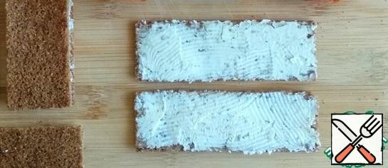 Thin polychetinkovye loaves are ideal for rolls.
So spread each slice with a thin layer of cottage cheese (I have with greens).