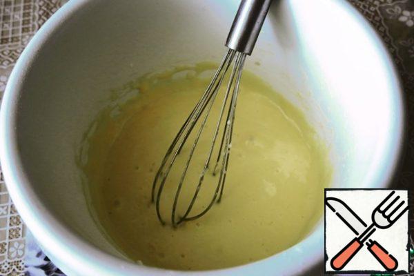Add flour and baking powder to the vegetable oil, mix with a whisk.
Divide 3 eggs into yolks and whites. Grate the yellow lemon zest on a fine grater, squeeze the juice from the lemon.