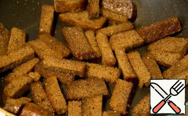 Borodinsky bread is cut into oblong pieces and fried in oil until it crunches.