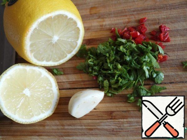 Finely chop the chili pepper, squeeze the garlic through the press, add the chopped parsley and lemon juice with olive oil.
