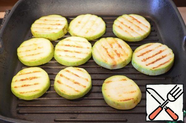 While the squid and salmon are being marinated, prepare the salad. Fry the zucchini, eggplant, sweet pepper, and onion on both sides in a dry pan. Place in a bowl, season with salt and drizzle with olive oil.