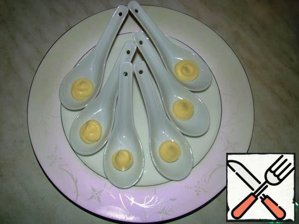 In porcelain spoons, squeeze out a little mayonnaise.