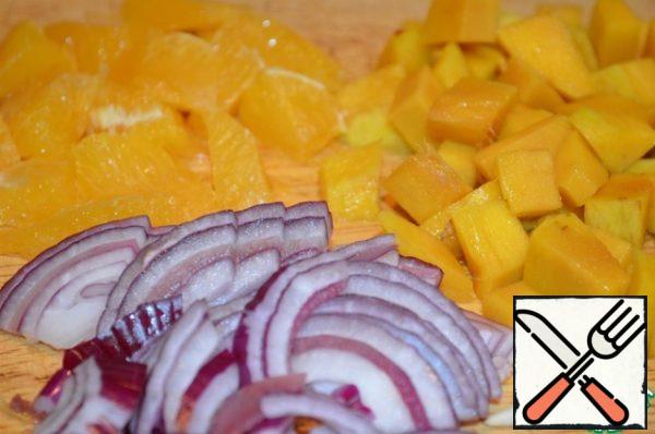 Cut the orange into two parts, set aside one half, it will come in handy later. Peel the other half of the orange, remove the segments and remove the films from them. Peel and dice the mango. Cut the onion into strips, and cut the chicken fillet into strips or small pieces.