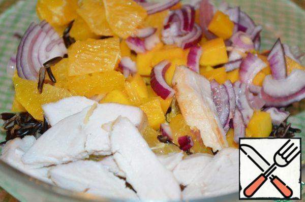 In a large bowl, add the cooled rice, chicken fillet, oranges, mango and onion.