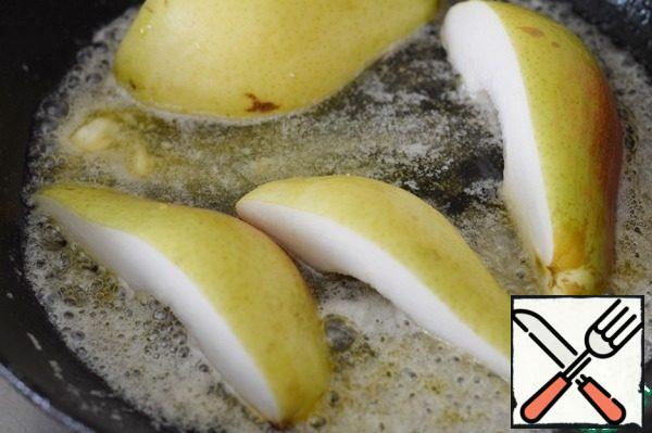 In a frying pan, melt the butter and sugar. Add a pinch of cinnamon and pepper. Lay out the pear slices and fry on all sides until golden brown.