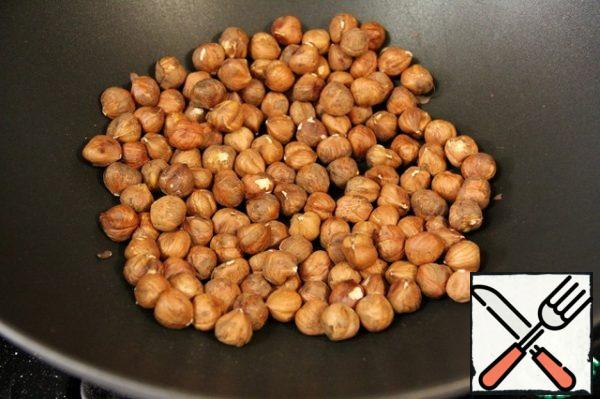 In a well-heated frying pan, put the hazelnuts and fry, stirring occasionally, for 10-15 minutes.