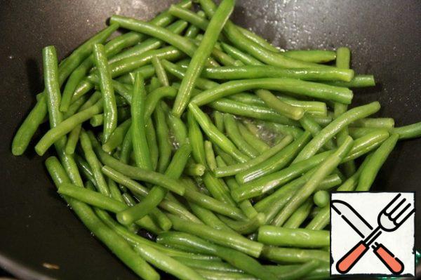 In the pan, add a little more oil, 1/2 cup of water and green beans. Cook over medium heat with the lid closed for about 5 minutes.