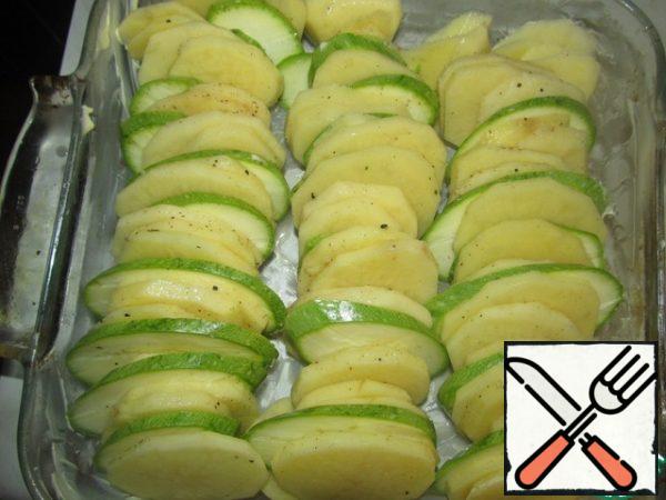 Peel the potatoes, cut the potatoes and zucchini into round pieces, 0.5 cm thick, add salt and pepper, add nutmeg, crushed and chopped garlic without a central core, lubricate the refractory form with butter and put the "packages" of potatoes and zucchini (see photo)