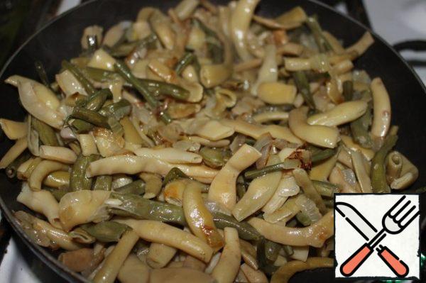 The sliced string beans are washed and boiled for 10 minutes in salted water. Drain the water. Wash, peel and finely chop the onion. In a frying pan, pour the vegetable oil, add the onion and fry a little. Add the beans, mix and fry for another 10 minutes on low heat.